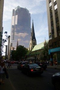 A church in downtown Montréal where you can see its steeple reflected in a nearby glass skyscraper